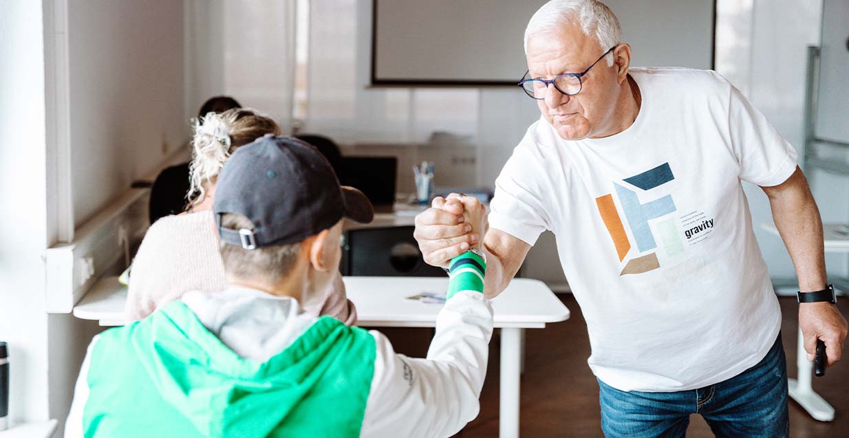Dozent gibt Kursteilnehmer Handschlag